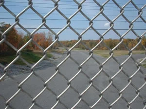 Galvanized chain link fence running beside a road