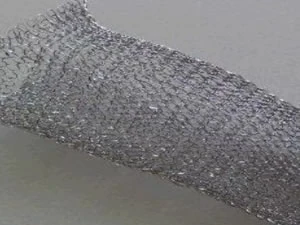 Knitted wire mesh strip partly compressed