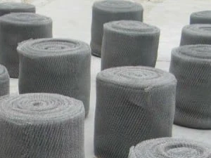 Rolls of knitted wire mesh standing on end
