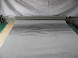 Wide roll of stainless steel wire cloth being unrolled