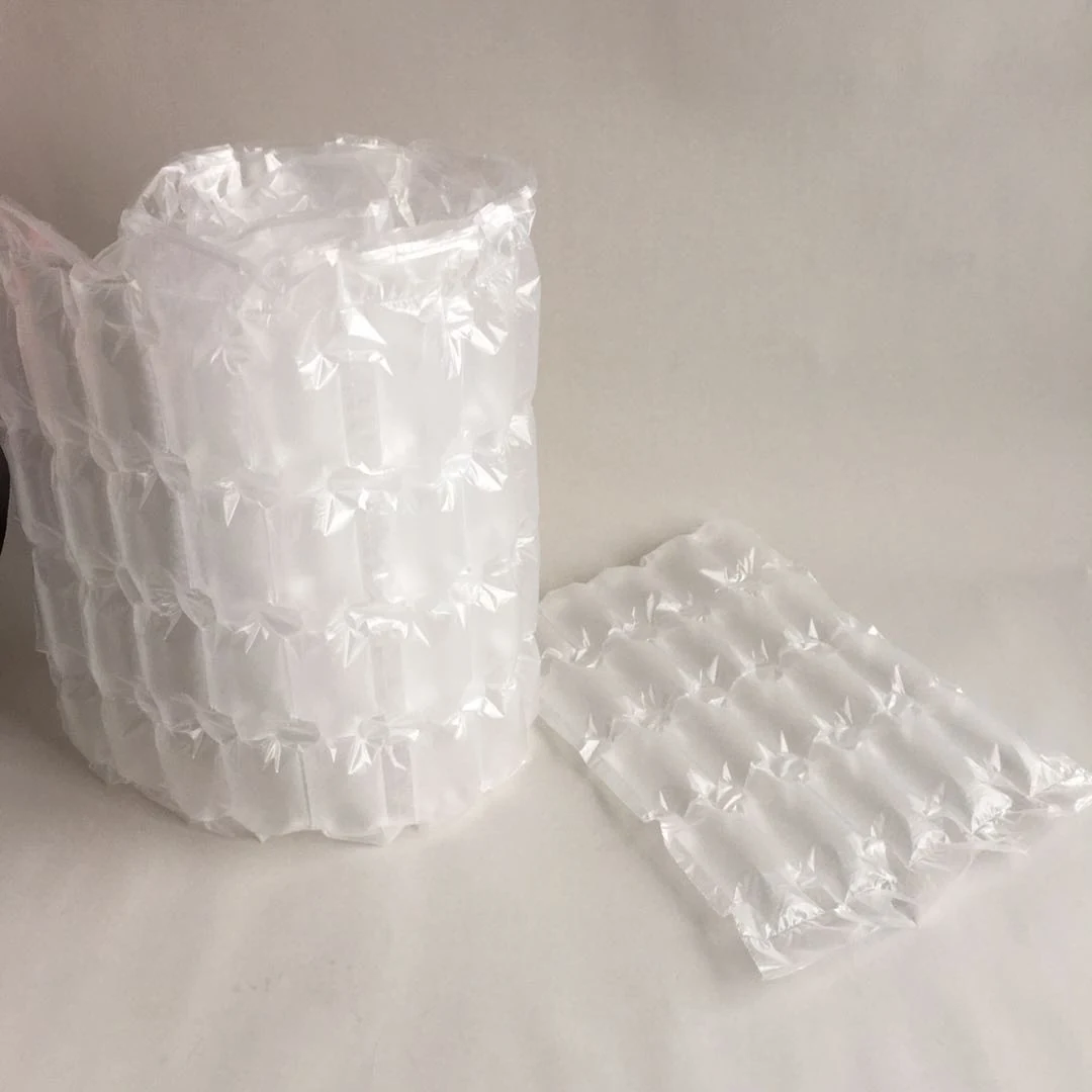 Roll of inflated air cushion packaging wrap beside a flat air column pillow sheet on a white surface