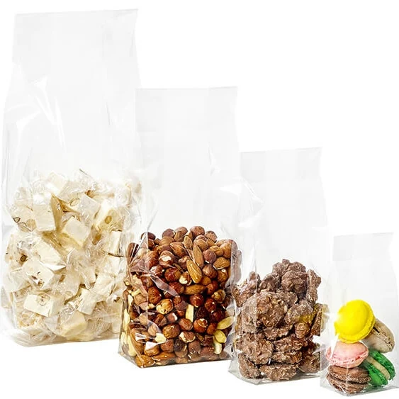 Four clear cellophane bags in descending sizes filled with nougat, mixed nuts, brittle, and macarons
