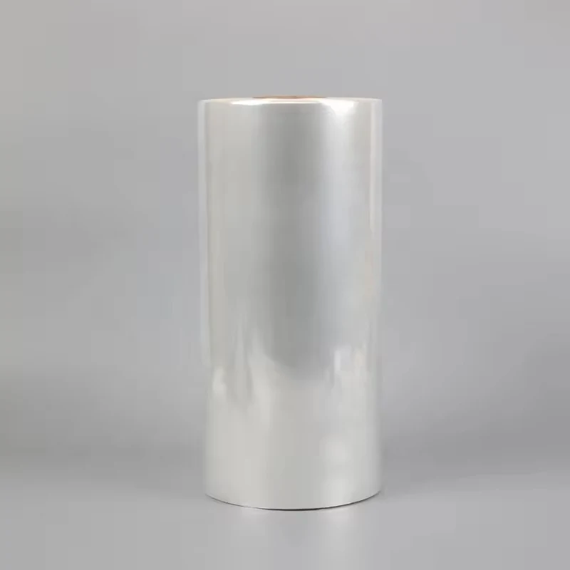 Large upright roll of clear plastic film on a plain gray background