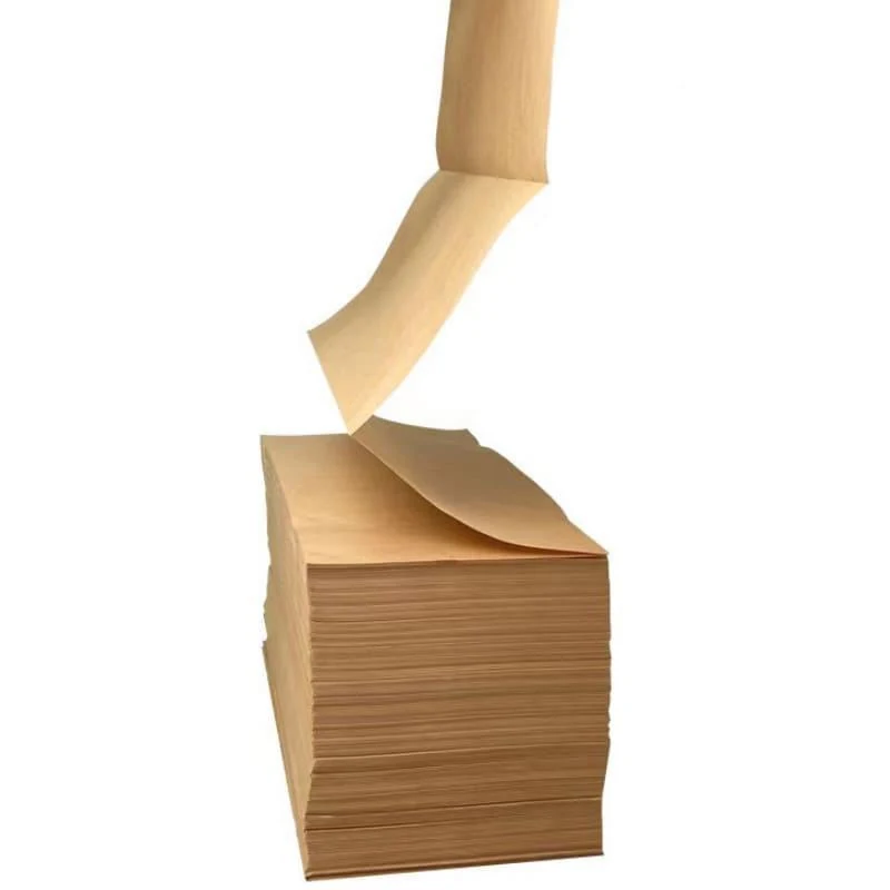 Stack of brown kraft paper sheets with one sheet lifting off the top against a white background