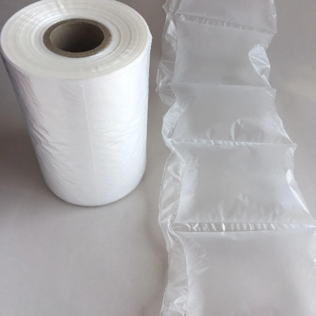 Roll of clear air cushion film beside inflated air pillow packaging columns on a white surface