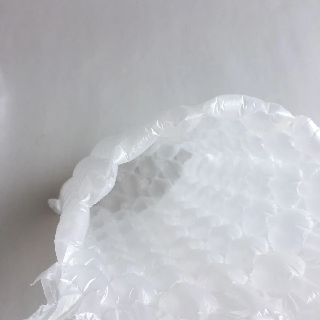 Close-up of white bubble wrap cushioning material on a plain light gray background