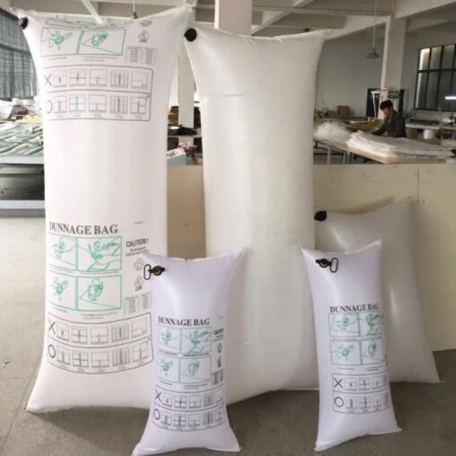 A group of inflated white dunnage bags of various sizes standing on a factory floor.