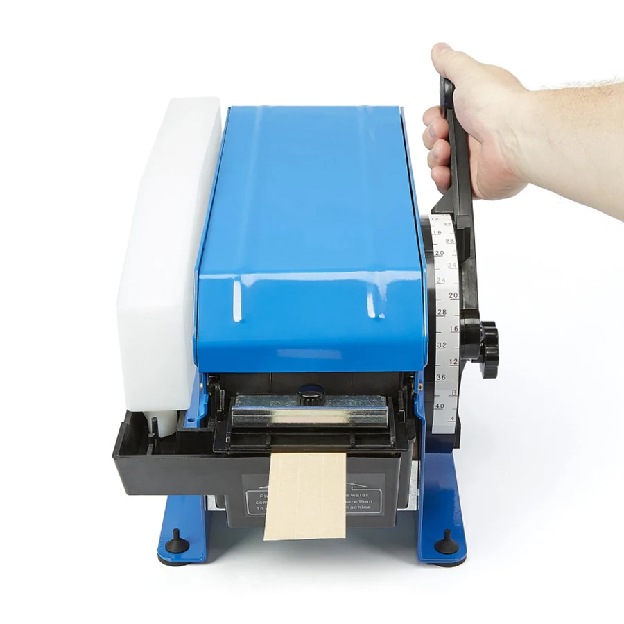 Hand-operated blue tape dispenser with pull lever and measurement scale dispensing kraft paper tape, white background
