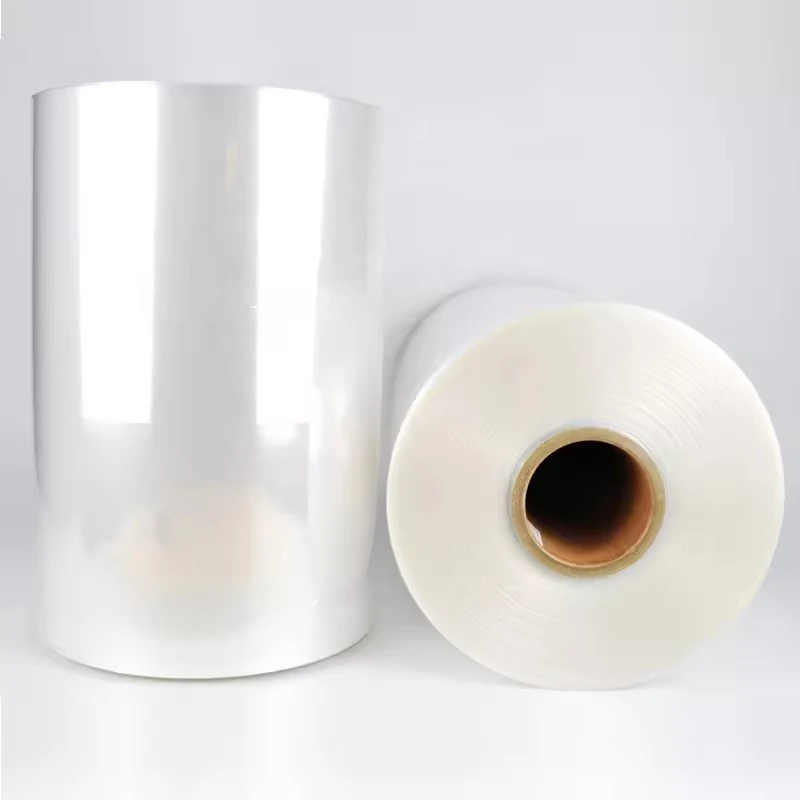 Two rolls of clear plastic film, one upright and one lying flat showing its cardboard core, on a plain white background