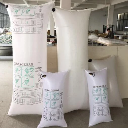 Multiple white inflatable dunnage bags of various sizes with printed instructions standing in a workshop