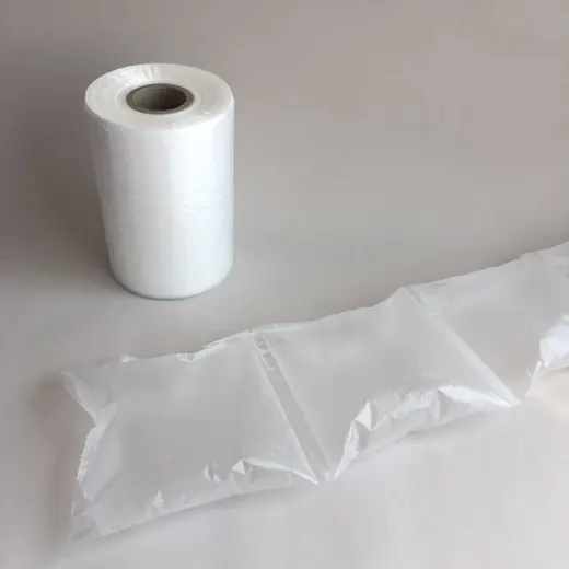 Roll of air cushion film beside a strip of inflated air pillow packaging on a plain light surface