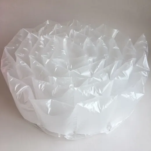 Coiled spiral of clear inflatable air cushion packaging film on a plain white background