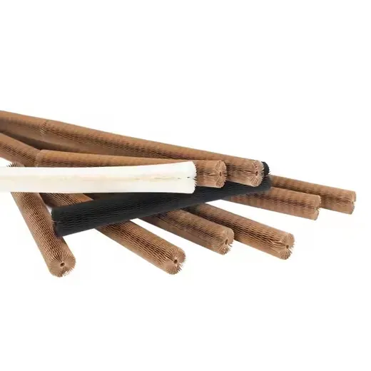 Group of cylindrical roller brushes with white, black, and tan bristles laid diagonally on a white background