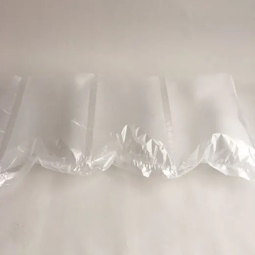 Clear inflated plastic air cushion packaging pillows lying on a plain white background
