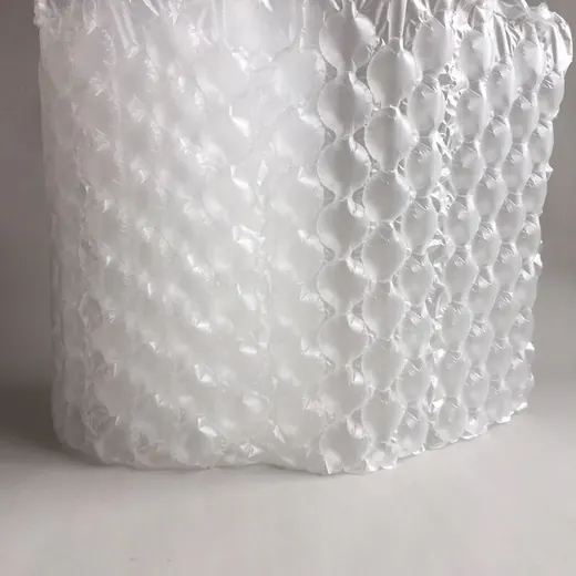 Roll of clear air bubble cushioning wrap standing upright on a plain light background