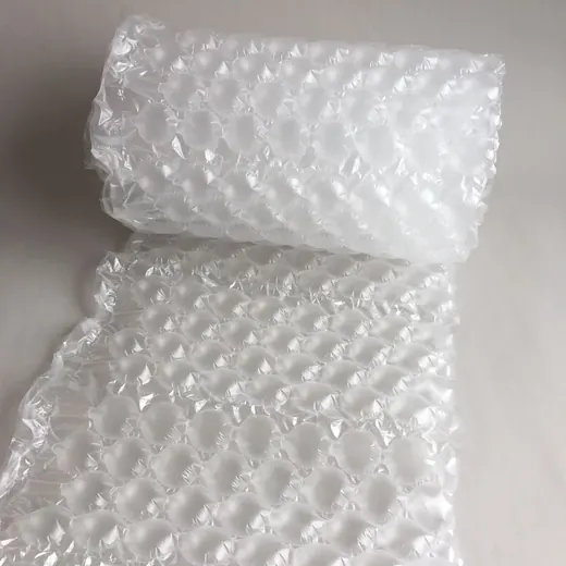 Roll of transparent bubble wrap packaging material partially unrolled on a plain light background