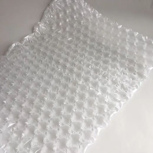 Translucent air cushion packaging sheet with rows of inflated air bubbles laid on a plain white surface