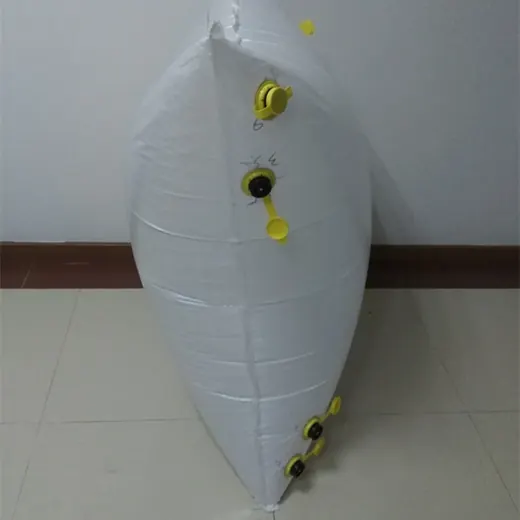White pillow-shaped flexible bladder tank with yellow valve fittings, leaning tilted against a plain indoor wall