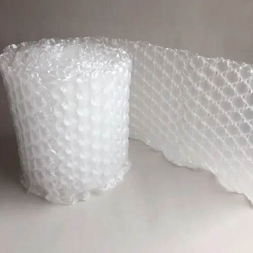Roll of clear bubble wrap packaging material partially unrolled on a plain white surface