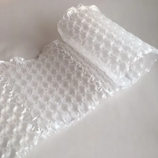 Sheet of clear plastic bubble wrap with a partially rolled end on a white surface