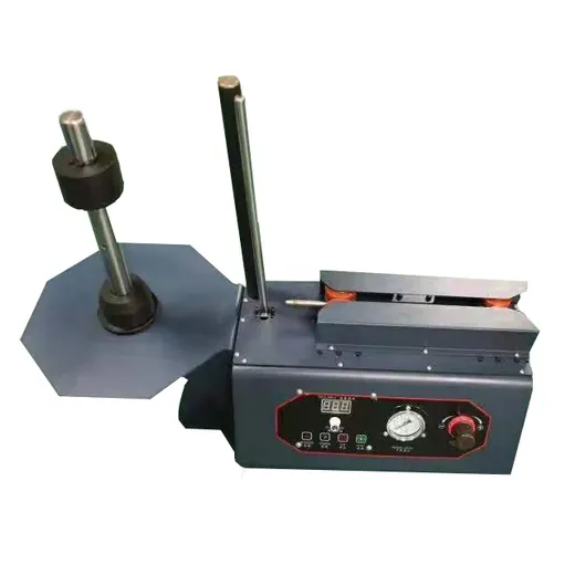 Industrial machine with a large roll holder on a stand and a control panel featuring a digital display and gauge.