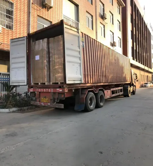 Open shipping container loaded with shrink-wrapped pallets on a flatbed truck