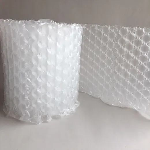 Roll of clear bubble wrap with a section unrolled, photographed on a plain light gray background