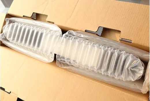 Clear inflatable air cushion packaging inside an open brown cardboard shipping box
