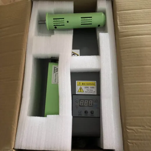 Green industrial hot air tool and control unit with digital display packed in white foam inside a cardboard box