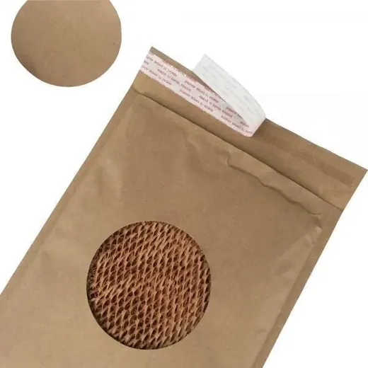 A brown kraft paper bubble mailer with a circular window showing honeycomb paper cushioning inside.