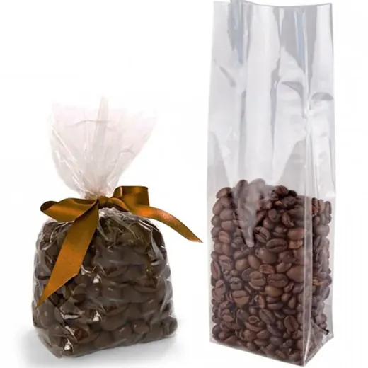 Two clear cellophane bags filled with coffee beans on a white background, one tied with a brown ribbon bow