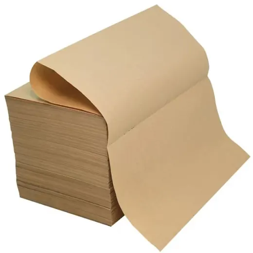Stack of brown kraft paper sheets with the top sheet curling upward, isolated on a white background