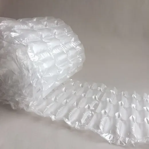 Roll of transparent inflated air cushion packaging film partially unrolled on a plain neutral background