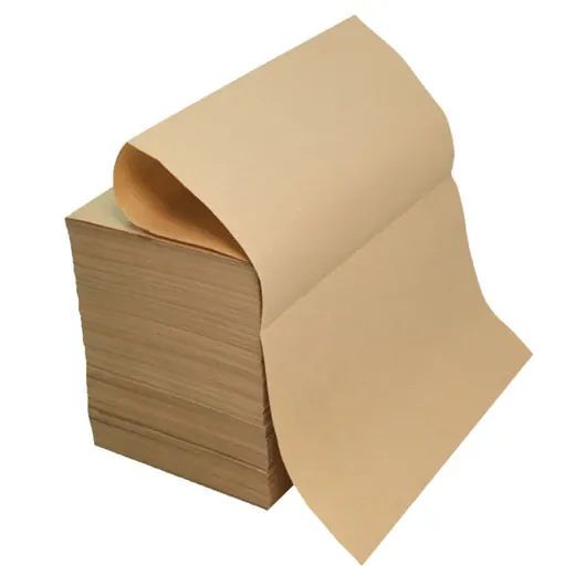 Stack of brown kraft paper sheets with the top sheet curling away, isolated on a white background