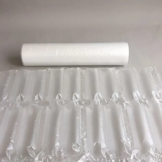 Roll of white plastic film behind a sheet of inflated air cushion packaging columns on a gray surface