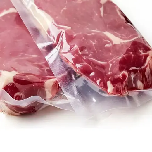 Raw marbled beef steaks vacuum-sealed in clear textured plastic pouches on a white background