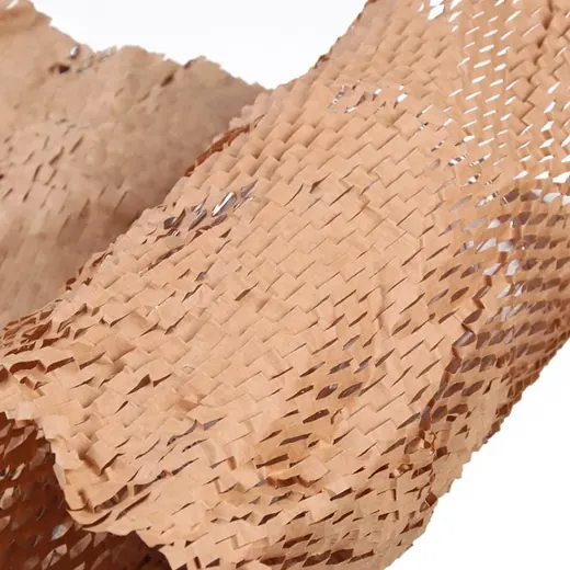 Close-up of brown kraft honeycomb wrapping paper with expandable die-cut pattern on a white background