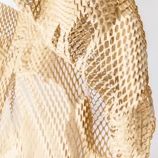 Crumpled kraft honeycomb paper wrap with open diamond mesh texture against a light gray background