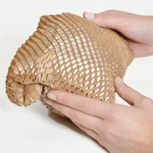 Hands holding and stretching a piece of brown honeycomb packing paper.