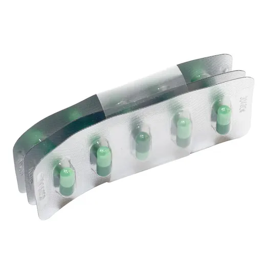 A blister pack containing green and white capsules on a white background.