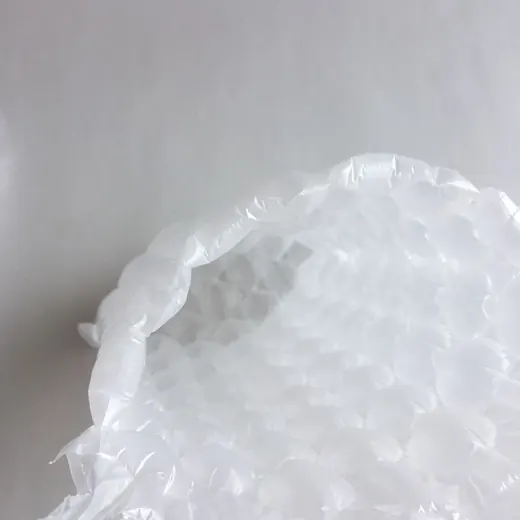 Close-up of white bubble wrap cushioning material on a plain light gray background