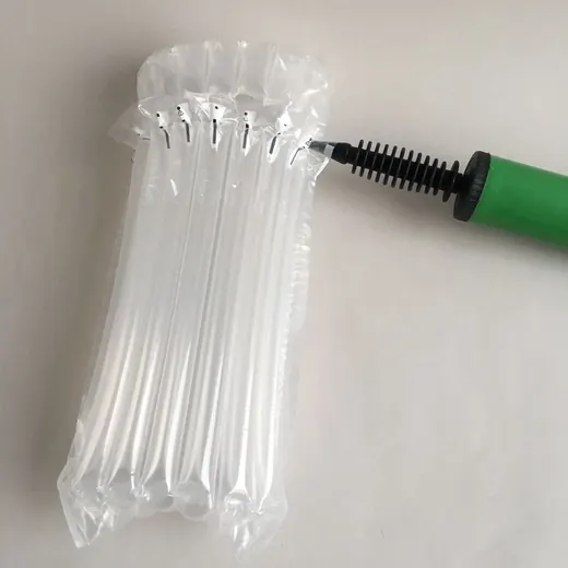 Green hand pump inflating clear inflatable air cushion packaging columns on a white surface