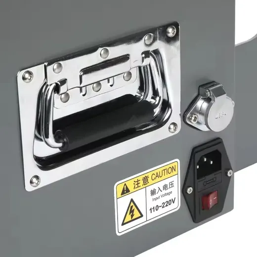 Close-up of a chrome spring-loaded pull handle, 110-220V power inlet, rocker switch and caution label on a gray machine panel.