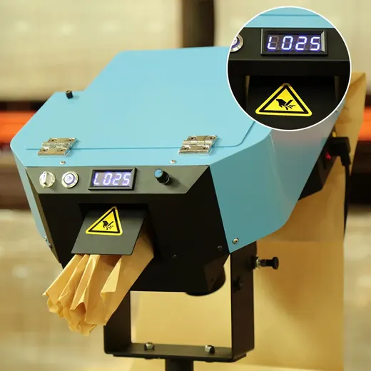 Blue industrial bag making machine with digital display and yellow safety warning sticker.