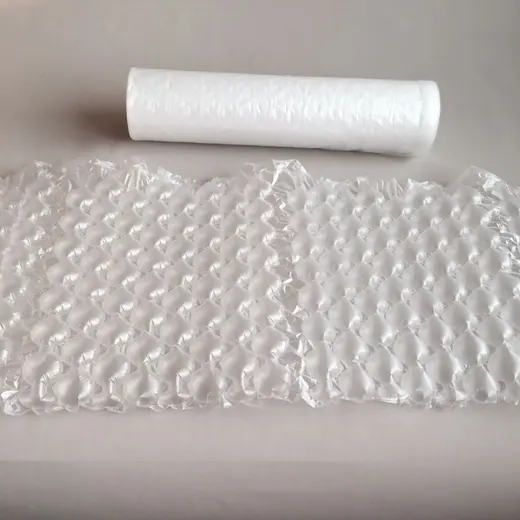 Roll of bubble wrap and a sheet of inflated air cushion packaging on a plain light background