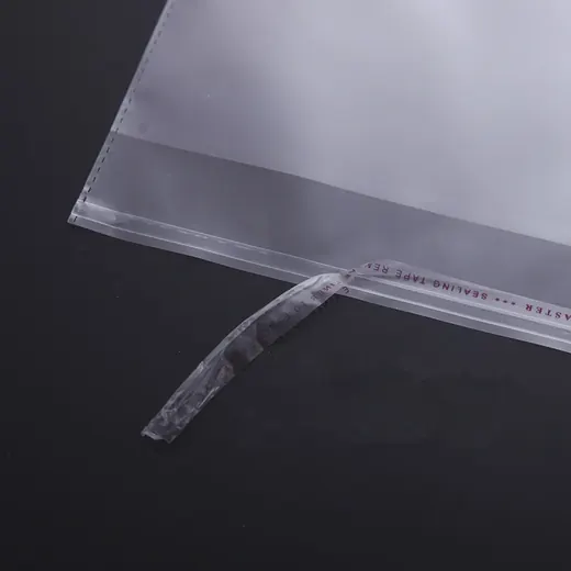 Close-up of a clear plastic mailing bag with a peel-and-seal adhesive strip against a dark background.