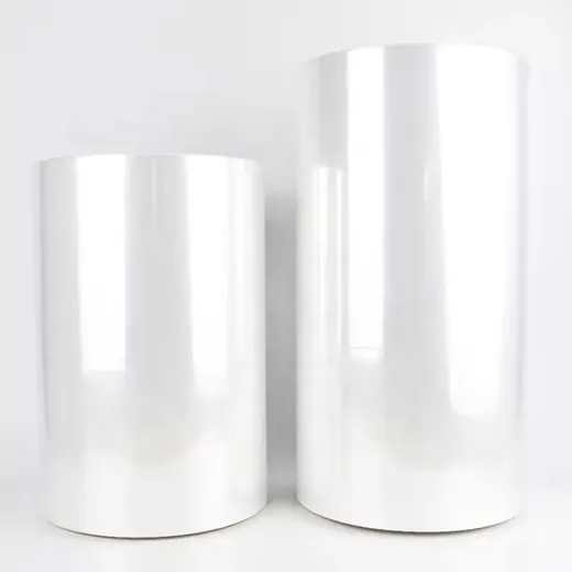 Two large upright rolls of clear plastic film against a plain white background