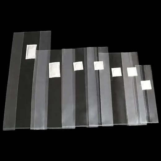 Row of translucent plastic bags with small white square patches, arranged in decreasing sizes on a black background
