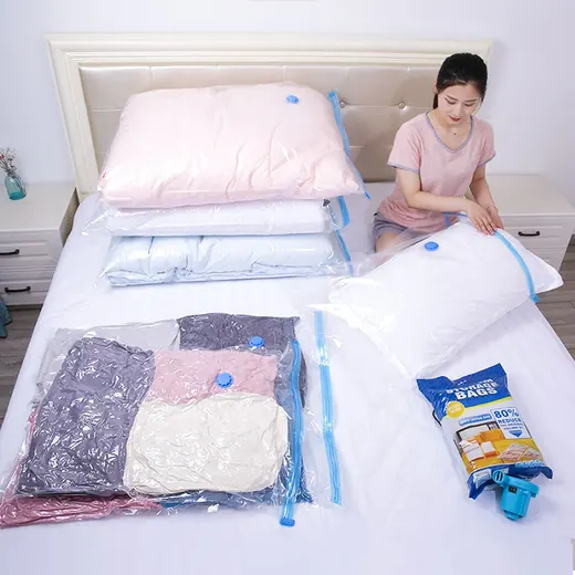 Woman sitting on a bed demonstrating vacuum storage bags filled with pillows and clothing alongside a small blue pump.