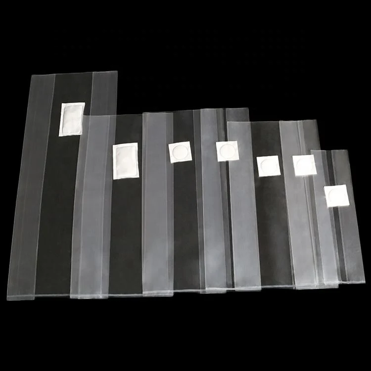 Row of translucent plastic bags with small white square patches, arranged in decreasing sizes on a black background